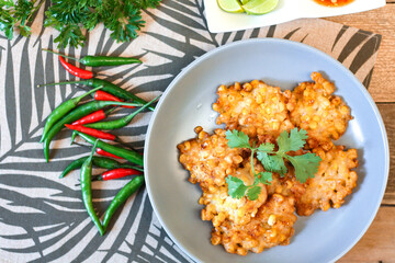 Corn Fritters With chili sauce placed on a wooden table