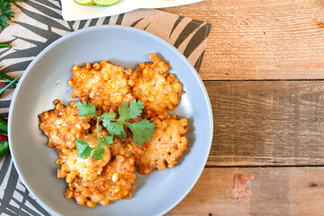 Corn Fritters With chili sauce placed on a wooden table