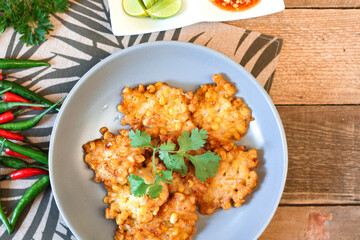 Corn Fritters With chili sauce placed on a wooden table