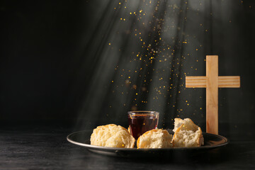 Glass of wine, bread and cross on dark background. Holy Communion concept