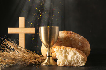 Chalice of wine with bread and cross on dark background. Holy Communion concept - obrazy, fototapety, plakaty