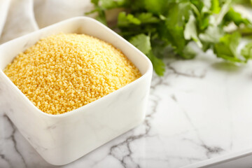 Bowl of raw couscous on tray, closeup