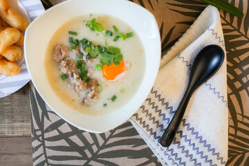 Chinese style porridge or porridge and fried dough stick or fried dough stick or donut or fried bread placed on a wooden table. Thai street food is called 
