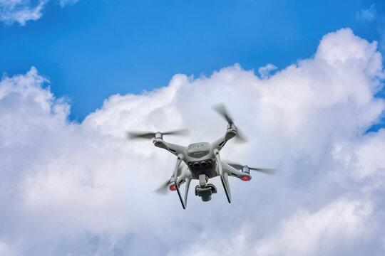 A white drone quadcopter taking off from the ground. Soft focus. Motion blur.