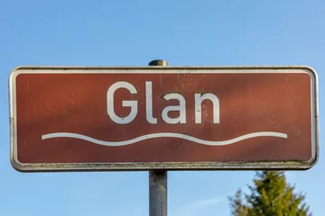 Foto op Plexiglas sign river Glan under blue sky with wave symbol and brown color © travelview
