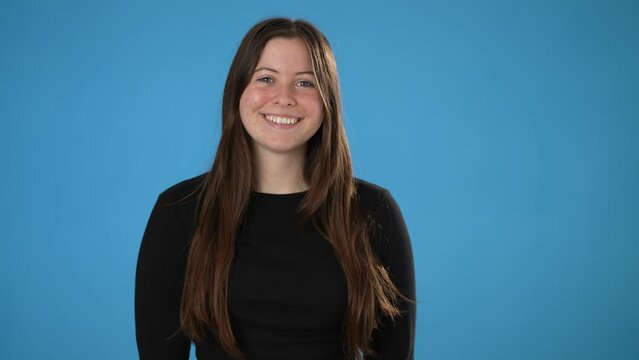 Portrait of happy smiling young brunette woman 20s wears black shirt isolated on plain blue background copy space studio portrait. People emotions lifestyle concept