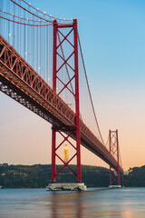 The 25 de Abril bridge over the Tajo River with Cristo Rei or Christ the King in the background. Lisbon. Portugal