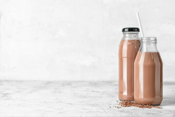 Bottles of delicious chocolate milk on grunge background