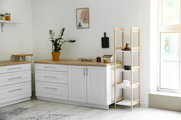 Interior of light modern kitchen with shelf unit