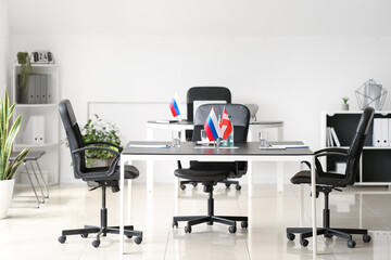 Flags of Austria, Spain and Russia on table in conference room