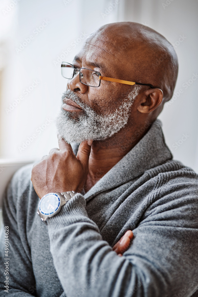 Poster he spends a lot of time deep in thought. shot of a handsome senior man looking thoughtful while rela