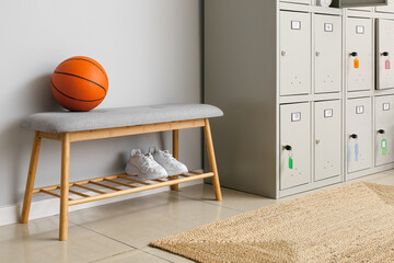 Locker with sport equipment and bench in change-room