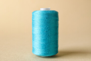 Blue sewing thread spool on light background