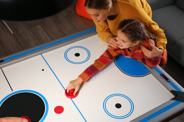 Family playing air hockey, top view