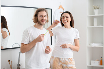 Lovely young couple brushing teeth in bathroom