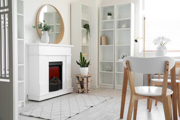 Fireplace and shelf units near white wall in stylish room interior