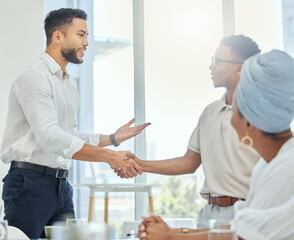 Obraz premium Its great to finally have you here. Cropped shot of two handsome young businessmen shaking hands during a meeting in the boardroom.