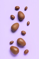 Delicious chocolate eggs on purple background