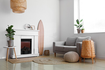 Interior of light living room with wooden surfboard and fireplace