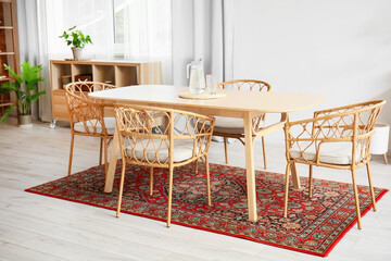 Interior of light dining room with table and vintage carpet