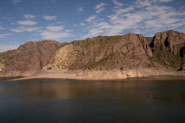View of the lake and rocky cliffs in the desert.
