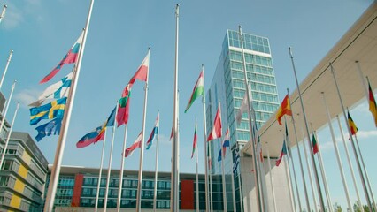 Waving Flags of European Union Countries in Court of European Parliament administrative office in Luxembourg City, Capital of EU. Politics, Economy and Global Business background. 4K panoramic shot - Powered by Adobe