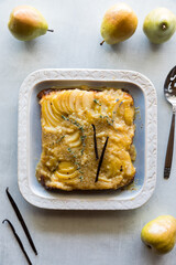 A decorative dish with a pear upside down cake, ready for serving.