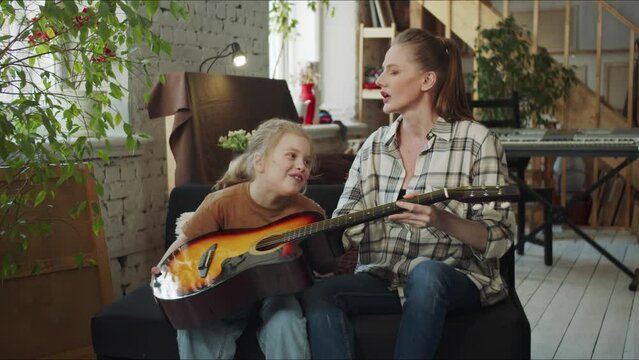 Mom persuades her daughter to play the guitar, but she refuses
