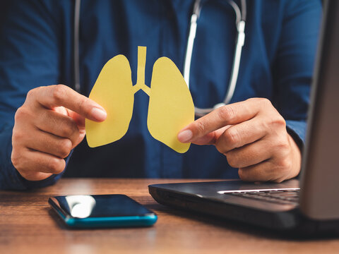 Doctor holding lungs symbol while sitting in the hospital