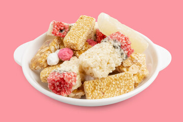 Candy comfit, Chinese sweetmeat or snack made of rice crispy bars, candied winter melon on white dish isolated on pink background