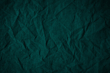 Green crumpled cotton fabric. Dark wrinkled cloth. Вackground with space for design.     