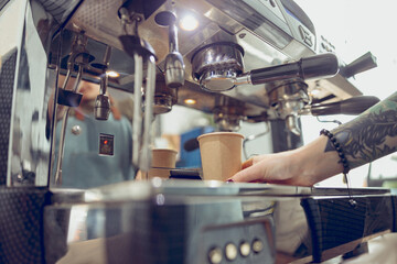 Female barista making espresso in coffee shop