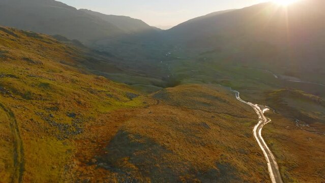 HARDKNOTT PASS Lake District Unesco National Park, Aerial Sunrise pull back through pass, sun dappling the mountains. Maviic 3 Cine Prores 422 - Clip 3
