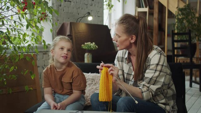 Mom chats with her daughter while knitting