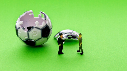 Football model and figurine on green background