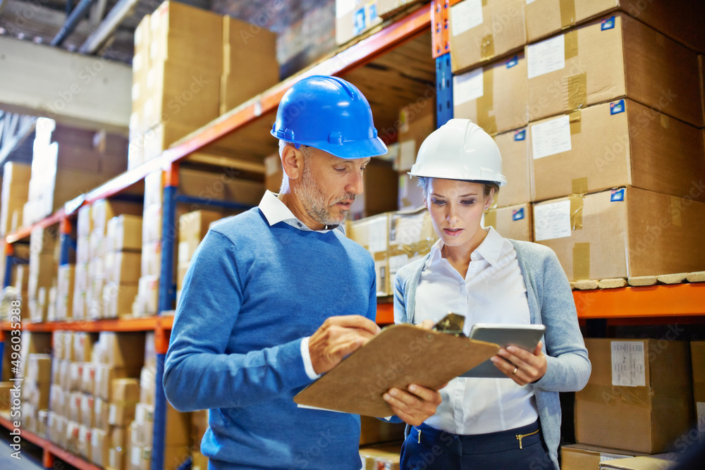 Aufkleber Putting their heads together to get it right. Shot of two people doing an inventory check in a warehouse.