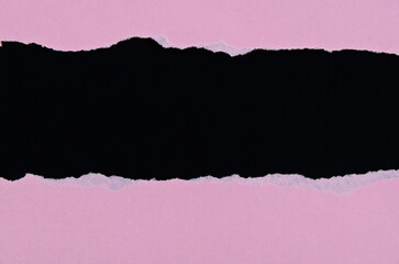 Pink torn paper on black background