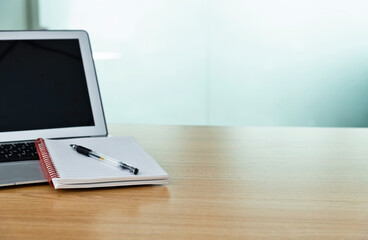 Blank notepad and laptop on the table