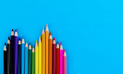 A row of color pencils on blue background