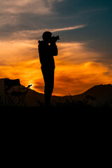 Photographer Ready to Take Sunset Pictures, dramatic sunset sky with young travel photographer, Photography concept image