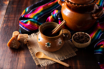 Cafe de Olla. Traditional Mexican coffee and basic ingredients for its preparation, coffee, cinnamon and piloncillo, served in a clay cup called 