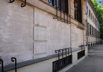 Wrought iron patterned grilles are installed outside on the first floor windows of the apartment...