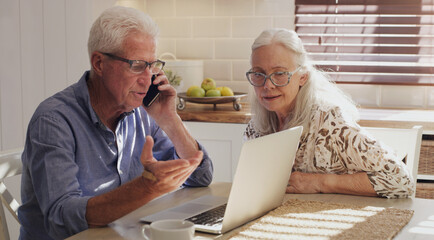 Fototapeta premium Theres an added charge I dont recognise. Shot of a senior couple sitting together in their kitchen at home and calculating their finances.