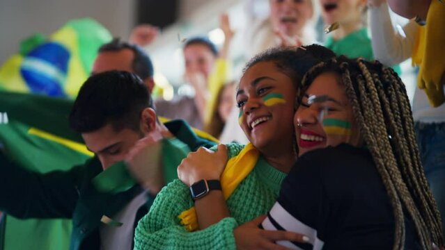 Brazilian young football fans celebrating their team's victory at stadium.