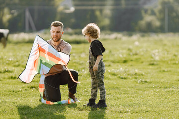 Father and son playing with a kite on summer outdoors
