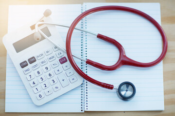 Clinical calculations. Closeup shot of a calculator and stethoscope resting on a notebook on a table.