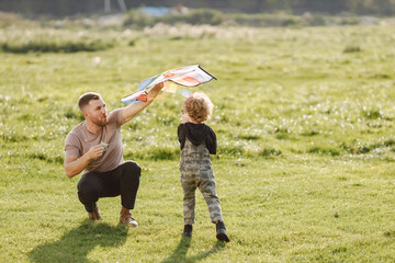 Father and son playing with a kite on summer outdoors