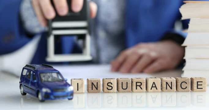 Agent stamps car insurance document closeup