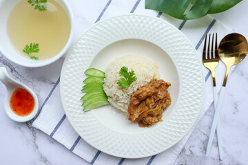 Hainanese fried chicken over oily rice with chili sauce in white plate  - Famous Singaporean food and in Thai called Khao Mun Gai Tord at top view