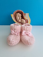 Baby fetus and pink baby slippers closeup